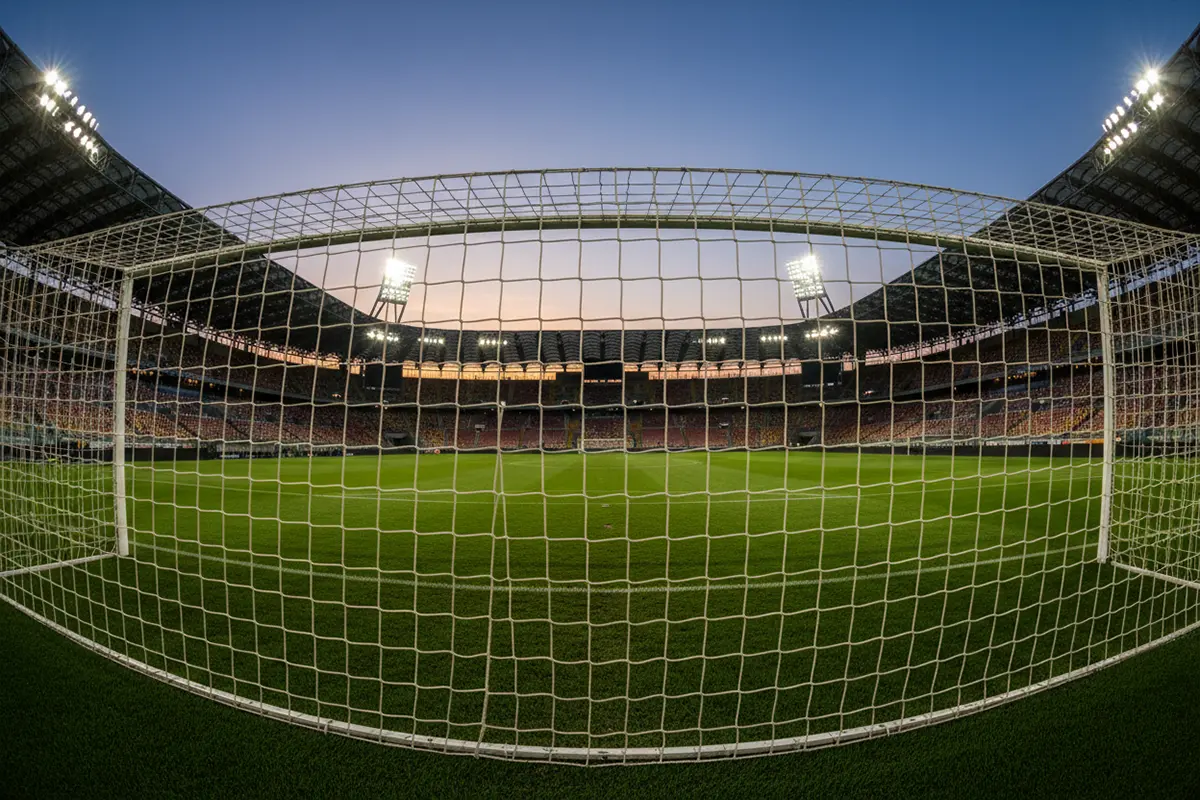 Stadio di calcio italiano con vista sul campo verde sotto i riflettori serali
