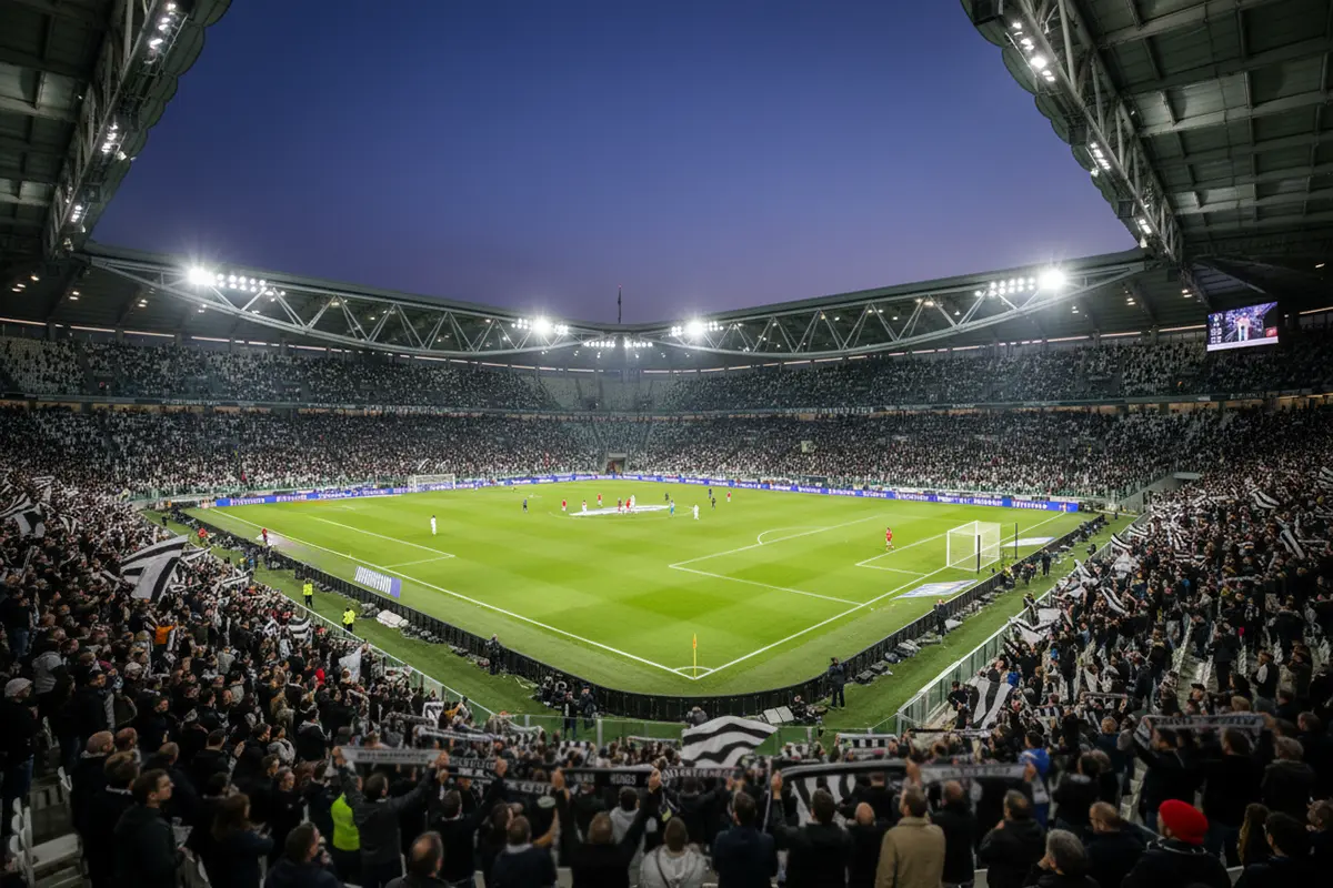 Allianz Stadium di Torino illuminato di notte con i colori bianconeri della Juventus