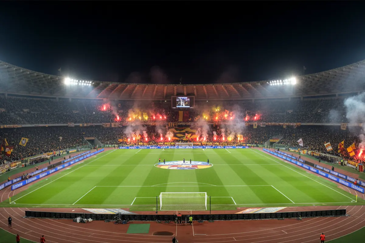 Stadio Olimpico di Roma illuminato durante una partita serale con la curva giallorossa