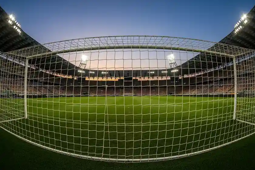 Stadio di calcio italiano con vista sul campo verde sotto i riflettori serali